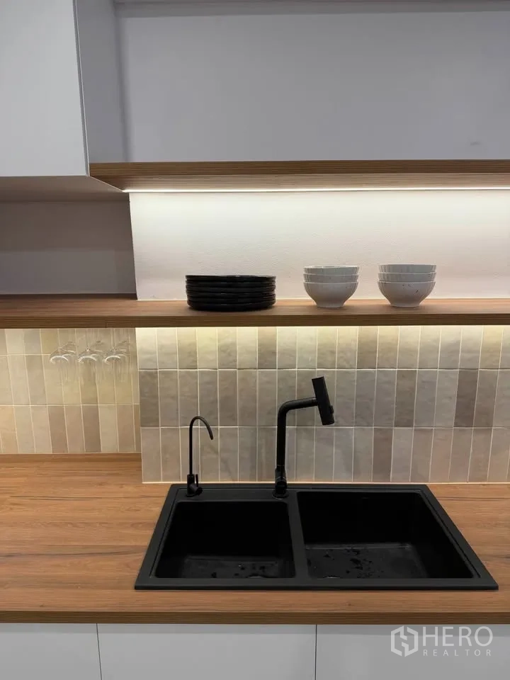 Condominium for rent in Watthana, Bangkok - Close-up of black double-basin sink with faucet and open shelf.