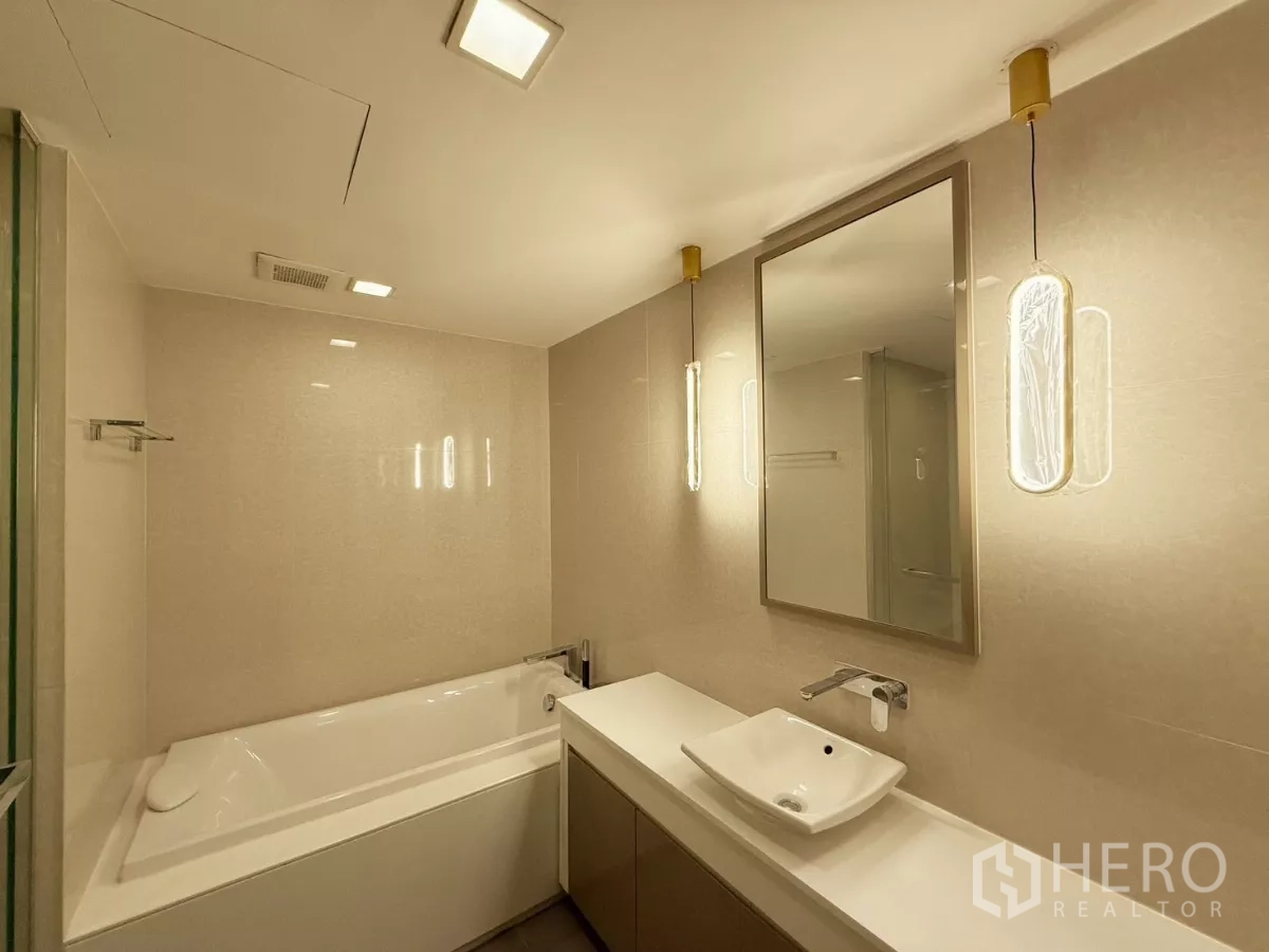 คอนโด ให้เช่าหรือขายในWatthana, Bangkok - ห้องน้ำในตัวมีอ่างอาบน้ำ แสงไฟนุ่มนวล และกระเบื้องโทนอ่อน