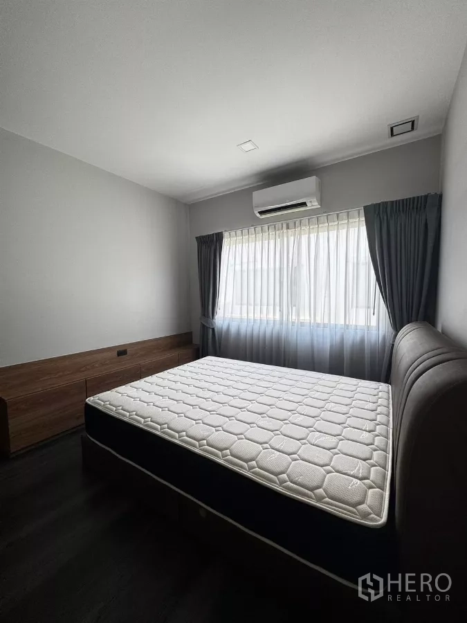 Townhouse for rent in Bang Phli, Samut Prakan - Bright secondary bedroom with bed, large window, curtains, and air conditioning.