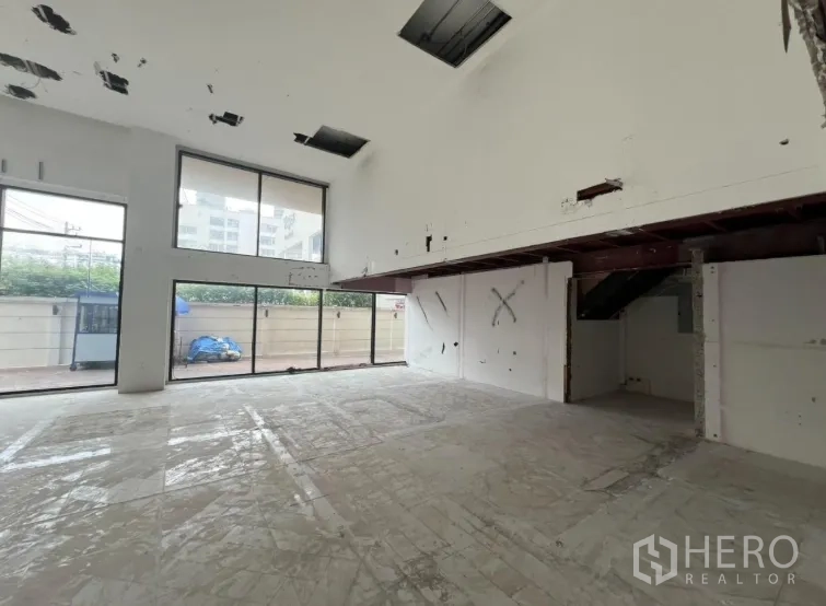 พื้นที่ขายปลีก ให้เช่าในWatthana, Bangkok - โซนโชว์รูมเพดานสูงพร้อมชั้นลอยและหน้าต่างยาว