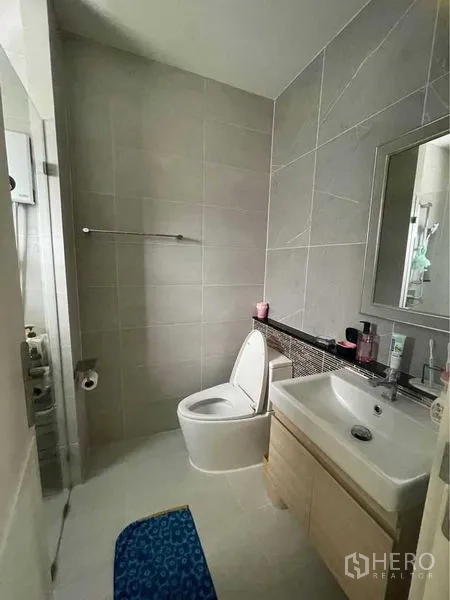 บ้าน ขายในLat Krabang, Bangkok - ห้องน้ำปูกระเบื้องมีอ่างล้างหน้า กระจก และโถสุขภัณฑ์ข้างโซนอาบน้ำ