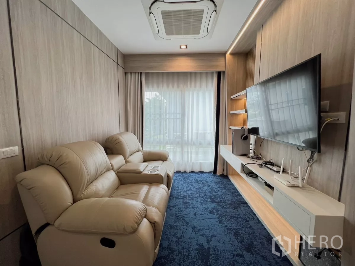 独立式住宅 出租或出售在Khlong Luang, Pathum Thani - 影音室，躺椅沙发、壁挂电视和蓝色地毯