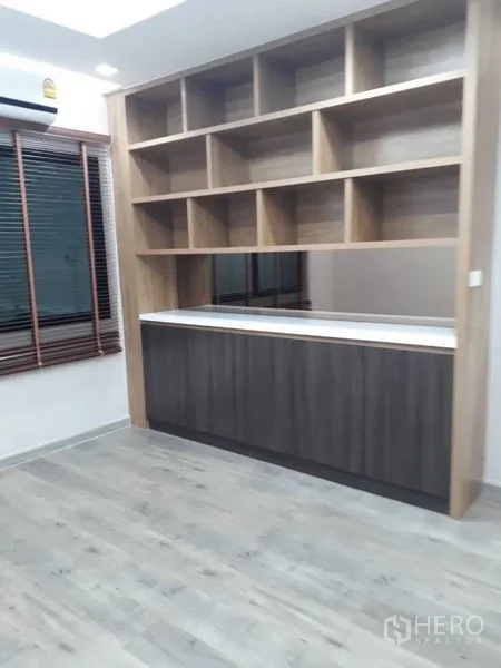 Detached House for rent in Thanyaburi, Pathum Thani - Multi-purpose room featuring a large built-in bookshelf and wood-look flooring.