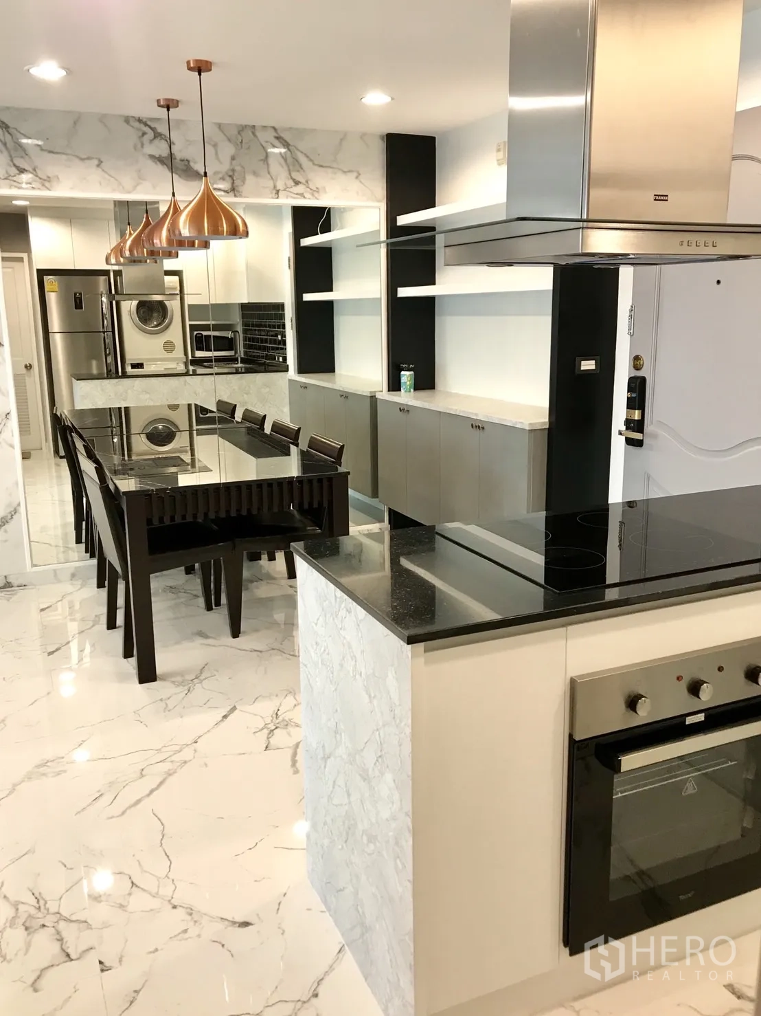 公寓 出租或出售在Khlong Toei, Bangkok - 开放式厨房与餐区，黑色石材台面、中岛炉台、烤箱与不锈钢烟机。