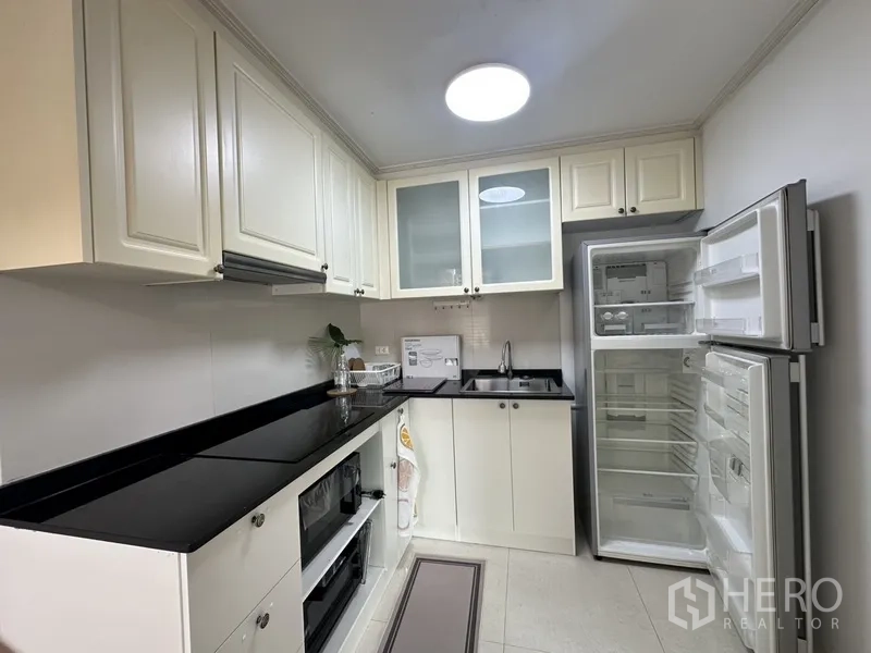 公寓 出租 - 封闭式厨房，白色橱柜、黑色台面，内置烤箱与双门冰箱