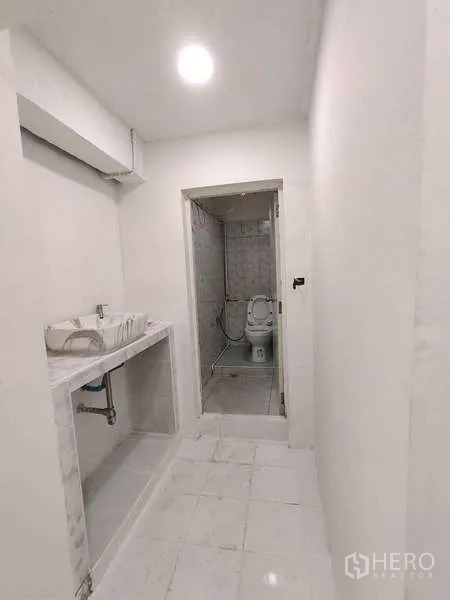 零售空间 出租在Din Daeng, Bangkok - 走廊带洗手台，连接到铺有瓷砖的卫生间。