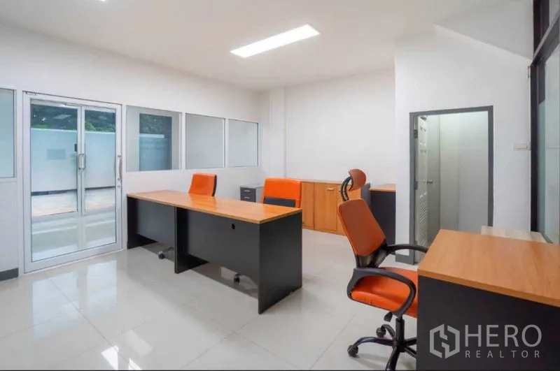 Home Office for rent or sale in Lat Krabang, Bangkok - Ground-floor office with orange chairs, built-in storage and glass entry doors.
