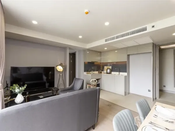 คอนโด ให้เช่าในPathum Wan, Bangkok - ห้องพักผ่อนมีทีวี ชุดรับประทานอาหาร และครัวขนาดกะทัดรัดโทนสีเทาเรียบ