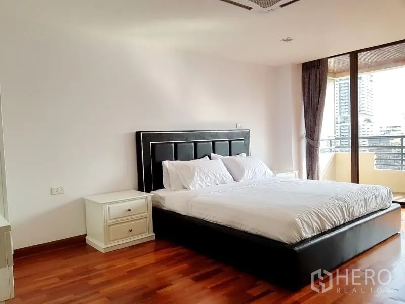 公寓 出租在Watthana, Bangkok - 采光充足的主卧，连通阳台，木地板与城市景观。