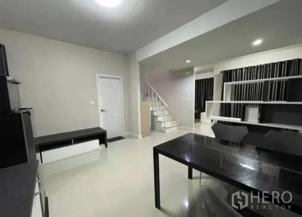 สำนักงานที่บ้าน ให้เช่าในSamut Prakan - ชั้นล่างกว้างขวาง มีโต๊ะทานอาหาร ชั้นวางของ และบันได เหมาะจัดเป็นห้องประชุม