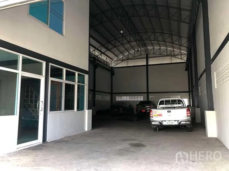 คลังสินค้า ให้เช่าในPak Kret, Nonthaburi - ทางเข้าโกดังพร้อมประตูกระจกสำนักงานและพื้นที่โหลดสินค้าคลุมหลังคา