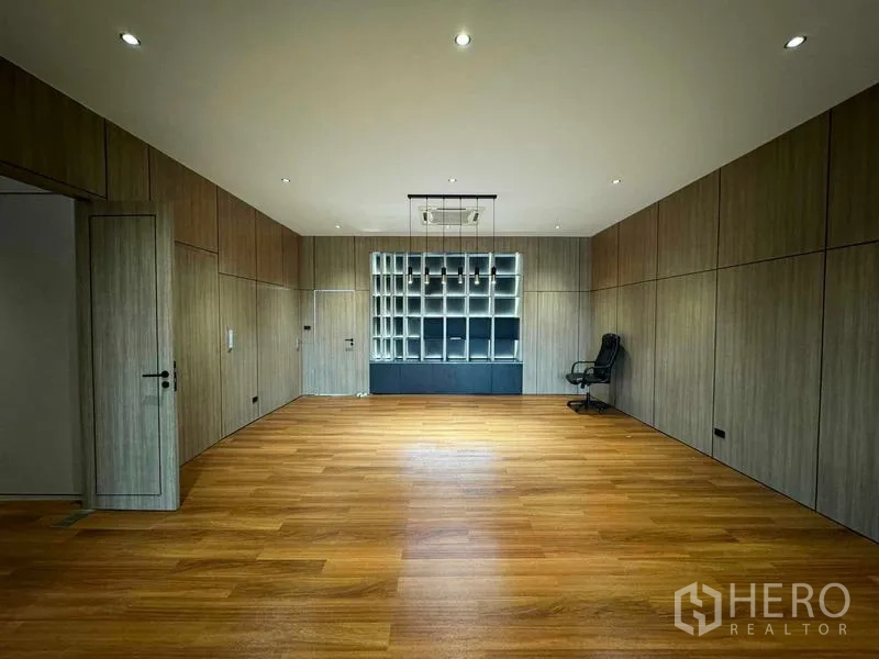 Home Office for rent or sale in Bang Phli, Samut Prakan - Large office room with built‑in shelving wall and warm wooden floors.