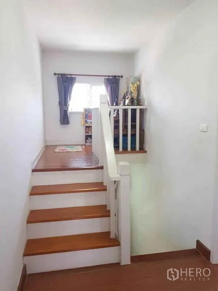 Detached House for sale in Nonthaburi - Upstairs landing with window, curtains and a small reading nook.
