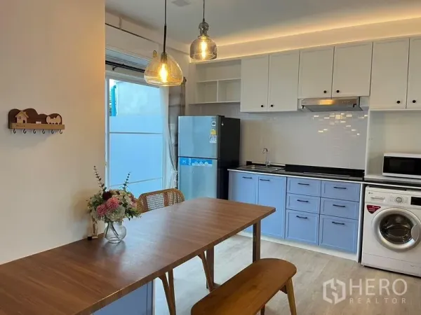 联排别墅 出租在Prawet, Bangkok - 现代厨房，蓝白橱柜，瓷砖墙面，冰箱、油烟机与洗衣机齐全。