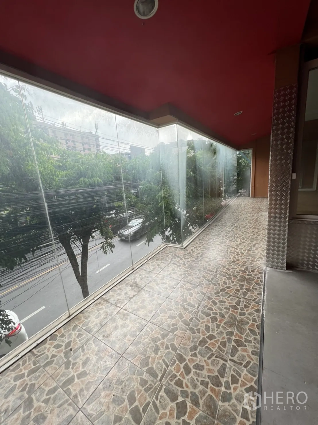 店屋 出租在Watthana, Bangkok - 封闭式阳台，仿石地砖与落地玻璃面向马路。