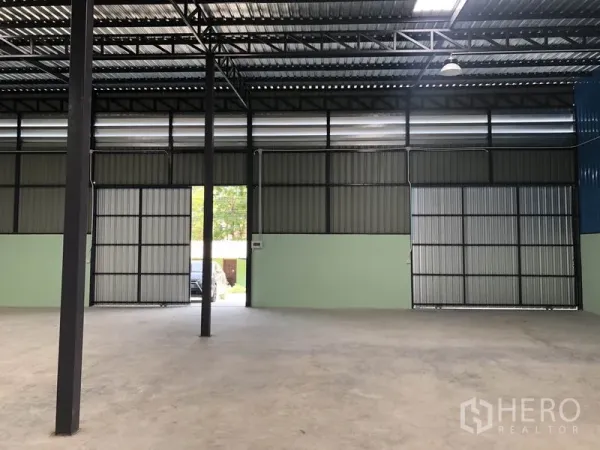 货栈 出租在Khlong Luang, Pathum Thani - 仓库内部空间宽敞，高钢桁架屋顶、混凝土地面与大型推拉门。