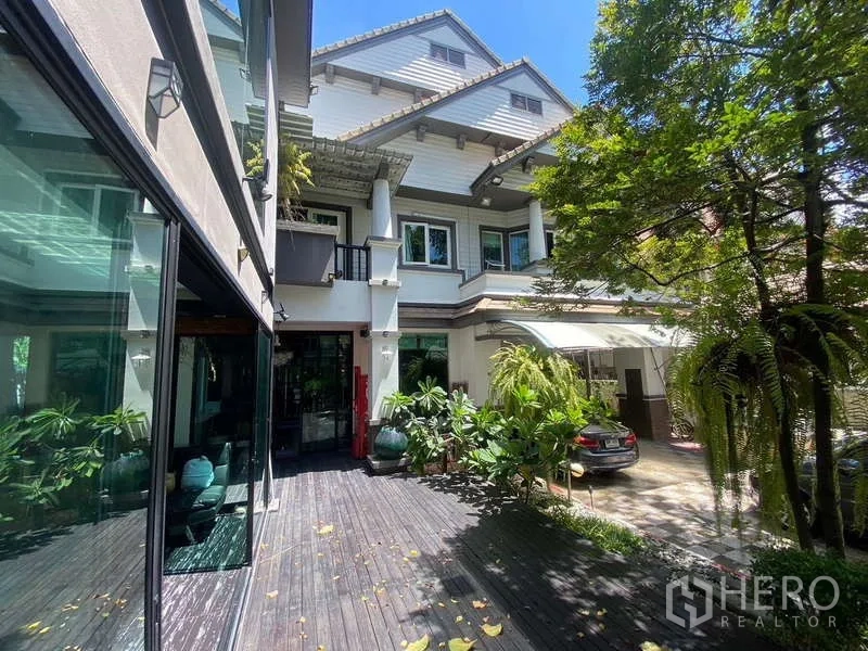 Detached House for sale in Suan Luang, Bangkok - Detached house exterior with wooden deck, large windows and lush plants.