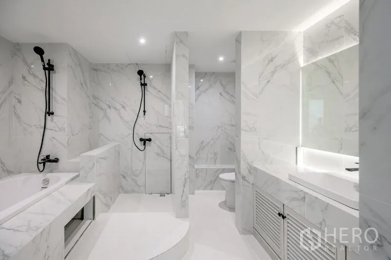 Condominium for sale - Luxurious marble bathroom with twin rain showers, bathtub, and toilet.