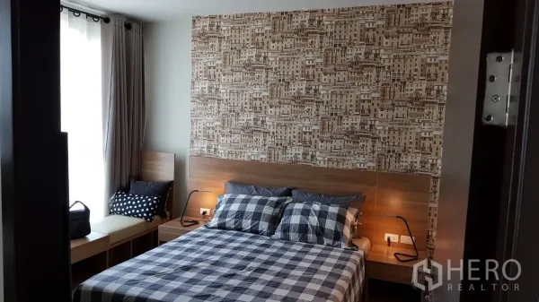 Condominium for rent in Sathon, Bangkok - Cozy bedroom with checkered bedding, wood headboard, feature wallpaper and a window seat by full-height curtains.