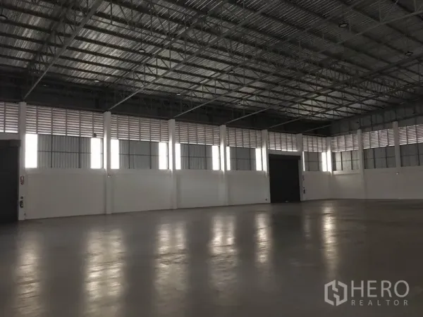 工厂 出租在Samut Prakan - 开阔的生产仓储大厅，设有多樘卷帘门与采光板，空间通透。