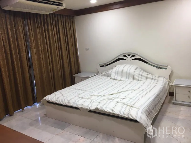 คอนโด ให้เช่าหรือขายในWatthana, Bangkok - ห้องนอนหลักพร้อมเตียงสีขาว โต๊ะข้างเตียง และผ้าม่านทึบในคอนโดเขตวัฒนา