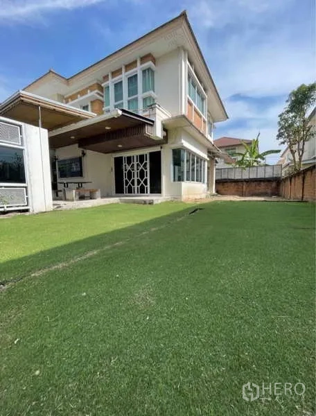 Detached House for rent in Bang Phli, Samut Prakan - Two-storey detached house exterior with wide private lawn and boundary wall.