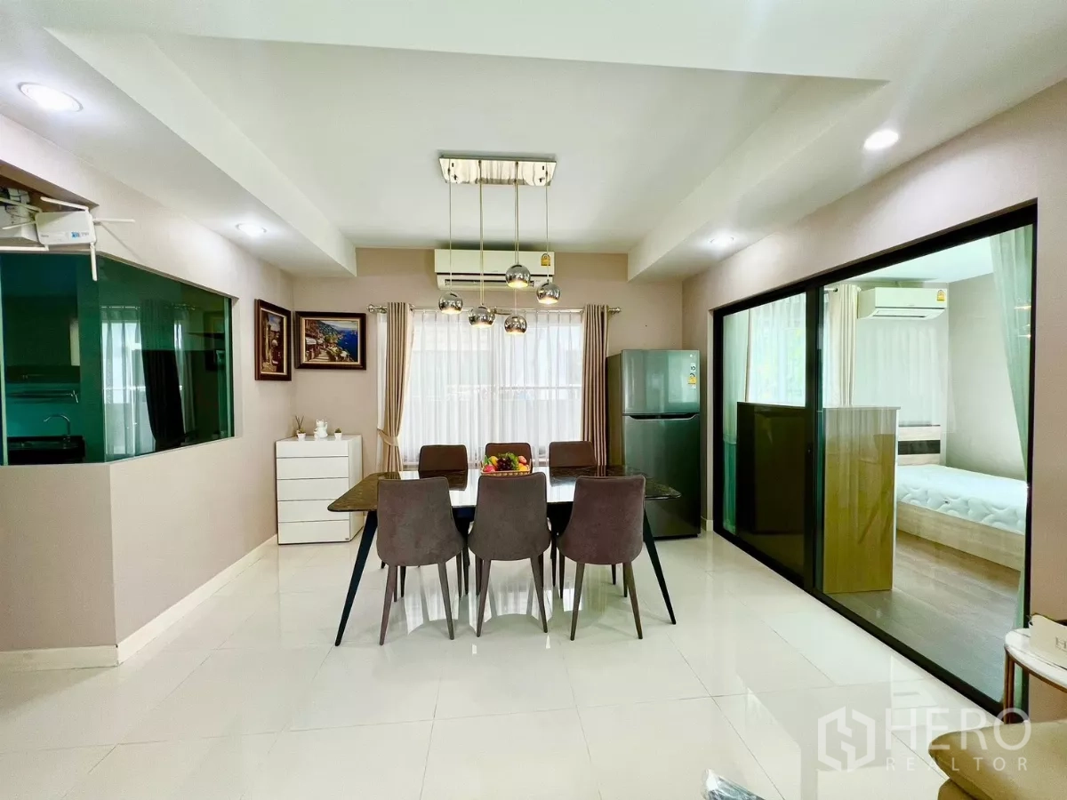Detached House for rent or sale in Bang Phli, Samut Prakan - Dining area with pendant lights, sliding glass doors and pass-through to the kitchen.