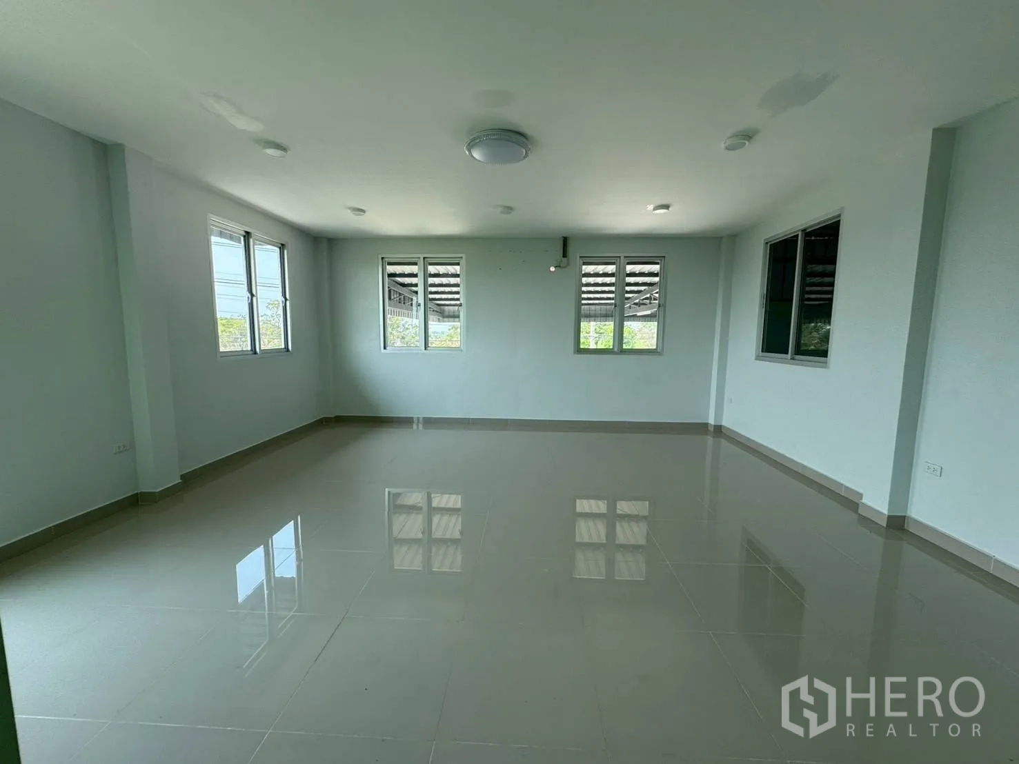 Warehouse for rent in Phutthamonthon, Nakhon Pathom - Bright upper-floor office area with tiled flooring and multiple windows.