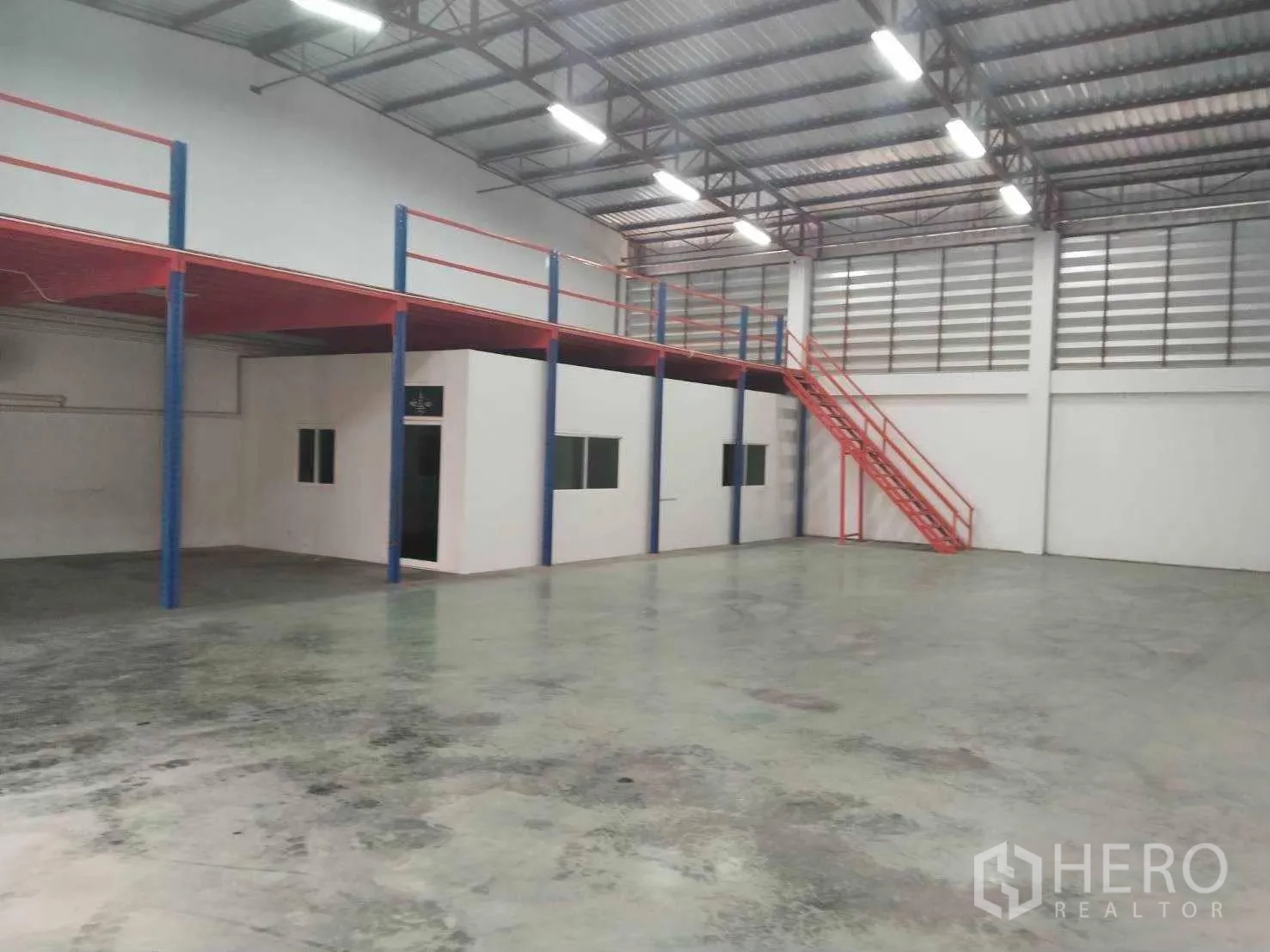 Warehouse for rent in Lat Krabang, Bangkok - Spacious warehouse interior with reinforced concrete floor, office block and red stair to mezzanine.