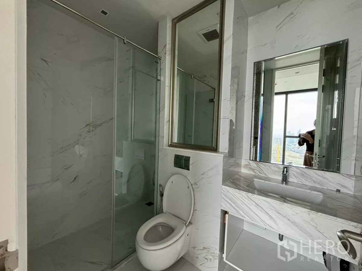 Condominium for sale in Bang Kho Laem, Bangkok - Contemporary bathroom with glass shower, vanity and window views.