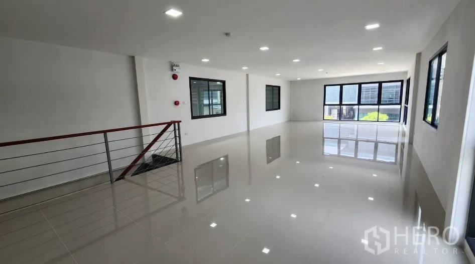 Factory for rent in Bang Bo, Samut Prakan - Another angle of the upper office showing railing, multiple windows and bright lighting.