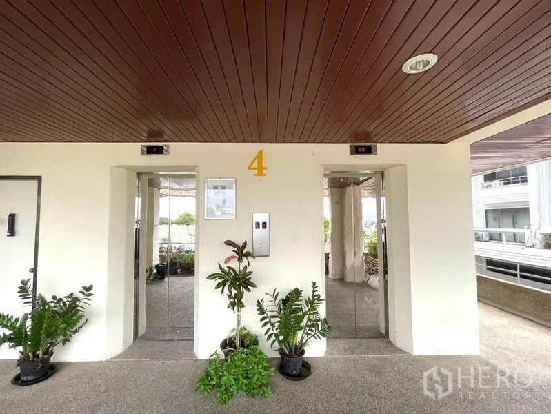 办公空间 出租在Khlong Toei, Bangkok - 四层电梯大厅，双电梯、木质天花与盆栽。