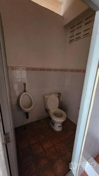 Warehouse for rent in Nong Khaem, Bangkok - Warehouse restroom with toilet, urinal, and tiled walls and floor.