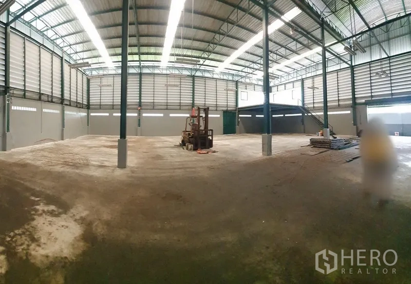 工厂 出租在Saphan Sung, Bangkok - 超大跨度厂房地面，屋顶天窗采光，钢柱、叉车与夹层平台。
