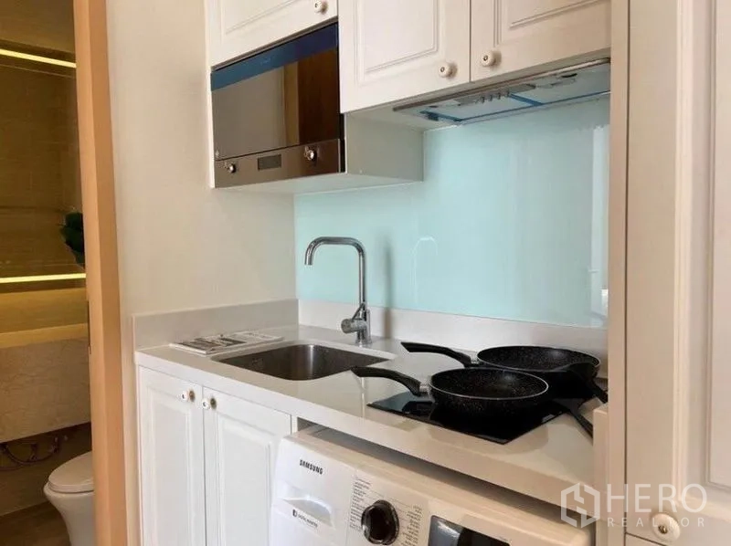 คอนโด ให้เช่าในWatthana, Bangkok - ครัวบิลท์อินสีขาว เตา ซิงก์ ไมโครเวฟ และเครื่องซักผ้า