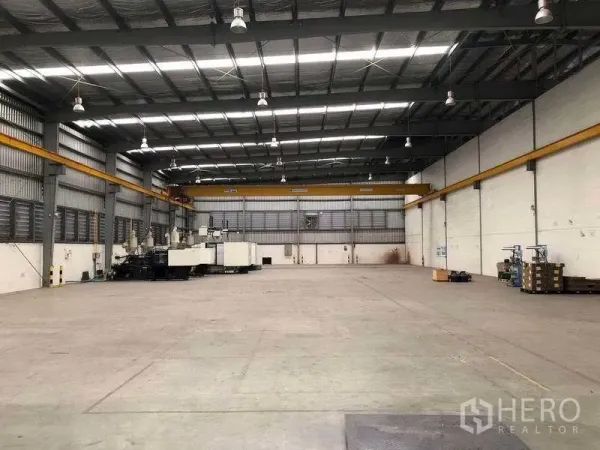 工厂 出租在Bang Sao Thong, Samut Prakan - 开阔仓库地面，设双行车与后部卷帘门。