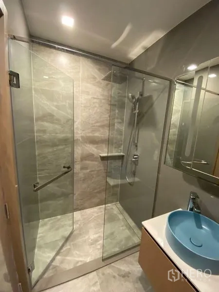 คอนโด ให้เช่าหรือขายในWatthana, Bangkok - ห้องน้ำสมัยใหม่ กั้นอาบน้ำกระจก เรนชาวเวอร์ และอ่างล้างหน้าสีฟ้าดีไซน์สวย