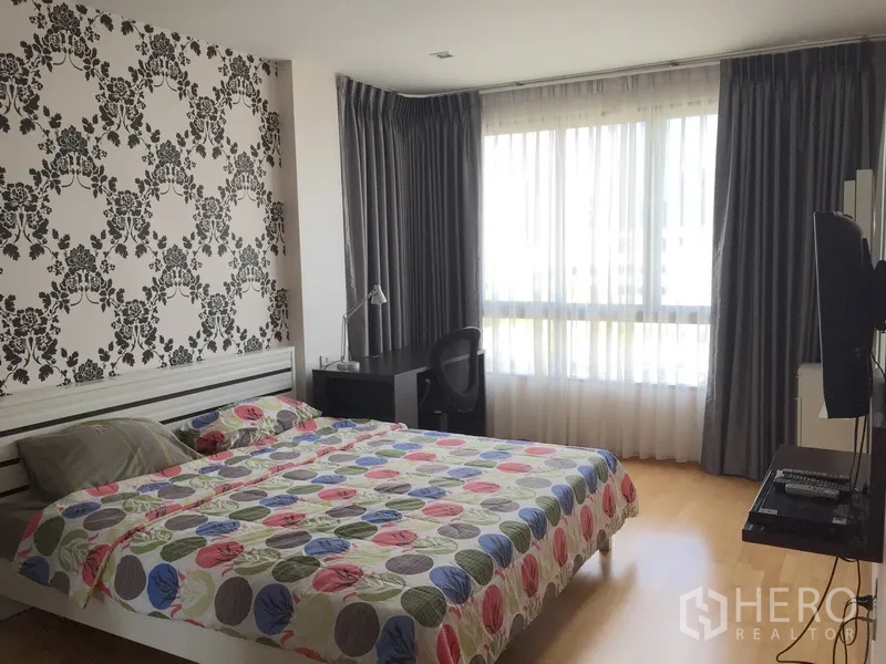 公寓 出租或出售在Khlong Toei, Bangkok - 主卧带花纹背景墙、大窗、书桌与壁挂电视。