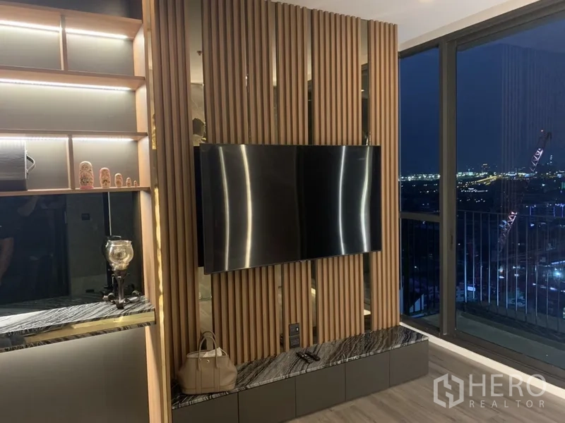 คอนโด ขายในPhra Khanong, Bangkok - ผนังทีวีลายซี่ไม้ติดระเบียง มองเห็นวิวสกายไลน์ตอนกลางคืน