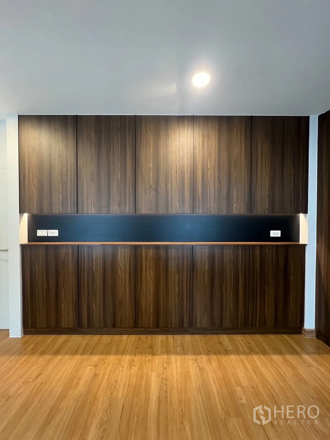Detached House for rent in Bang Phli, Samut Prakan - Wall of built-in storage cabinets in warm wood finish with accent lighting.