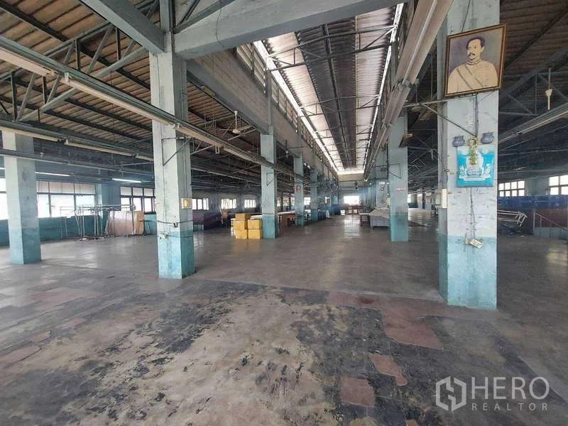 Warehouse for rent in Min Buri, Bangkok - Spacious high-ceiling warehouse interior with steel trusses, skylight strip and open concrete floor.