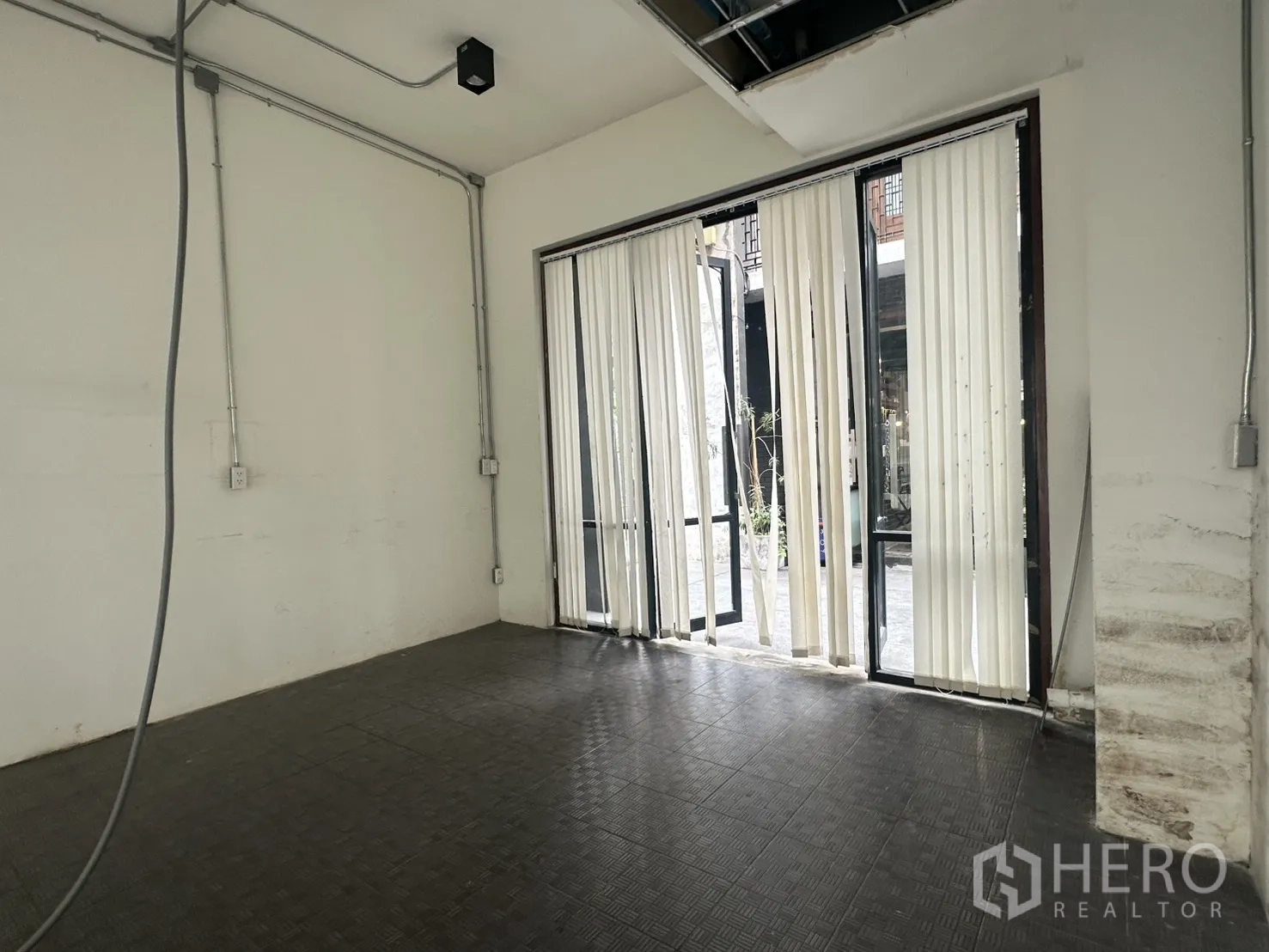 带办公室的家 for rent in Pathum Wan, Bangkok - 一层房间，推拉玻璃门与竖百叶通向庭院步道。
