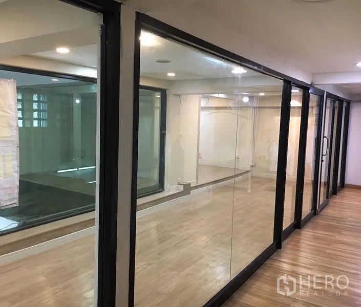 零售空间 出租在Watthana, Bangkok - 玻璃围合的零售空间，吊顶筒灯与复合木地板。