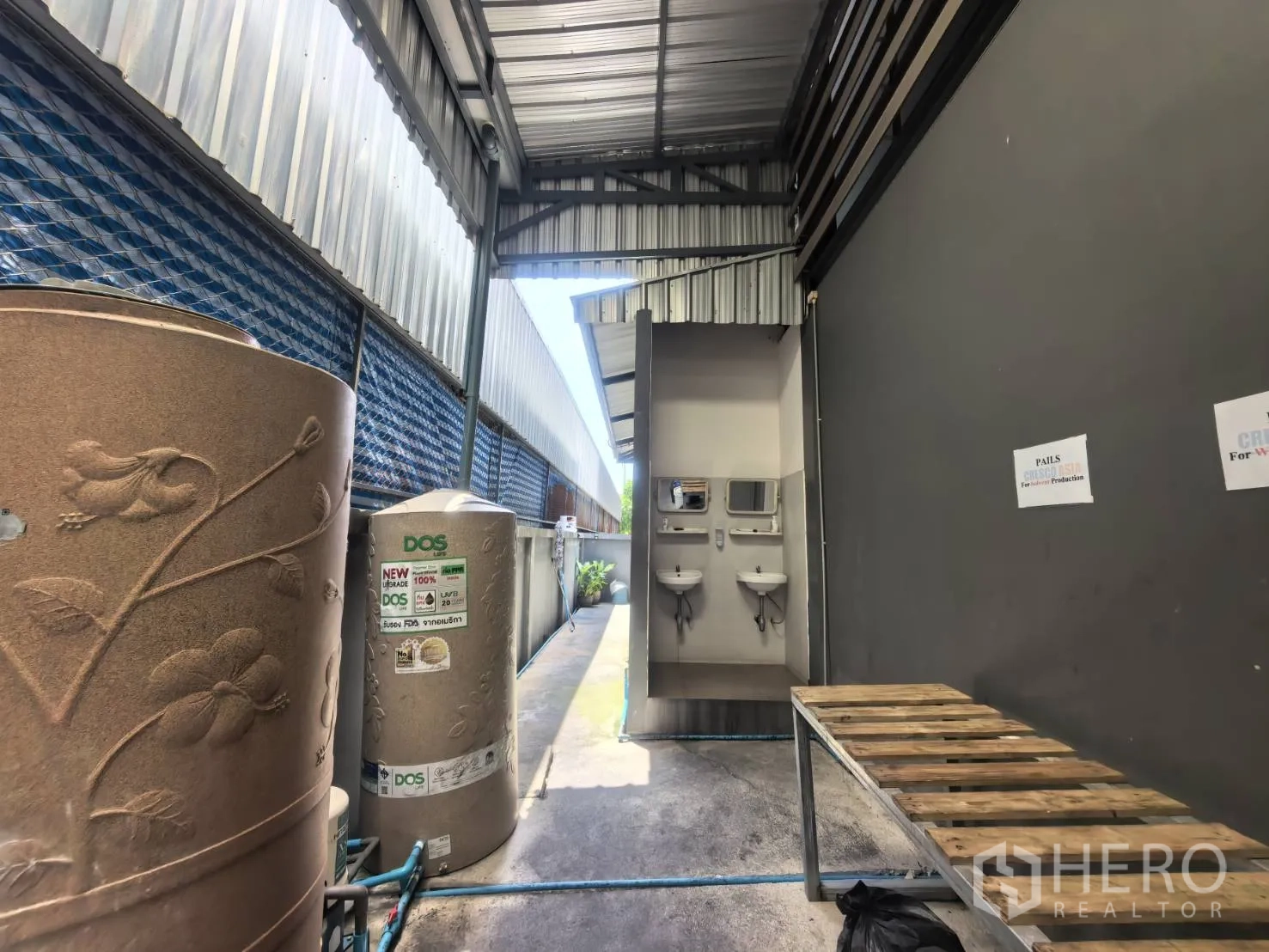Warehouse for rent in Bang Sao Thong, Samut Prakan - Covered side walkway with water storage tanks and double wash basins.