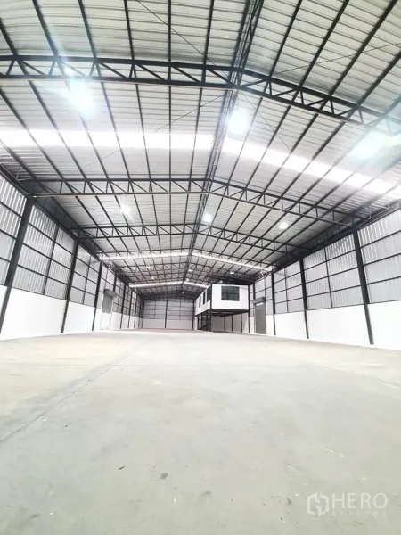 货栈 出租在Bang Khen, Bangkok - 开阔无柱库厅，灯光明亮，尽头设有架空盒式办公室。