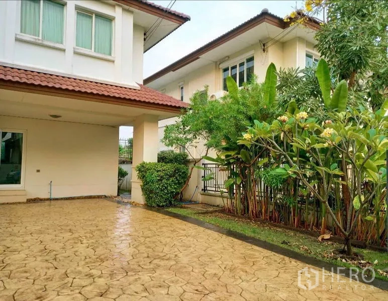 บ้าน ให้เช่าหรือขายในBang Yai, Nonthaburi - ที่จอดรถและทางรถเข้าปูพื้น ข้างสวนจัดแต่งมีต้นไม้ใหญ่และพุ่มไม้