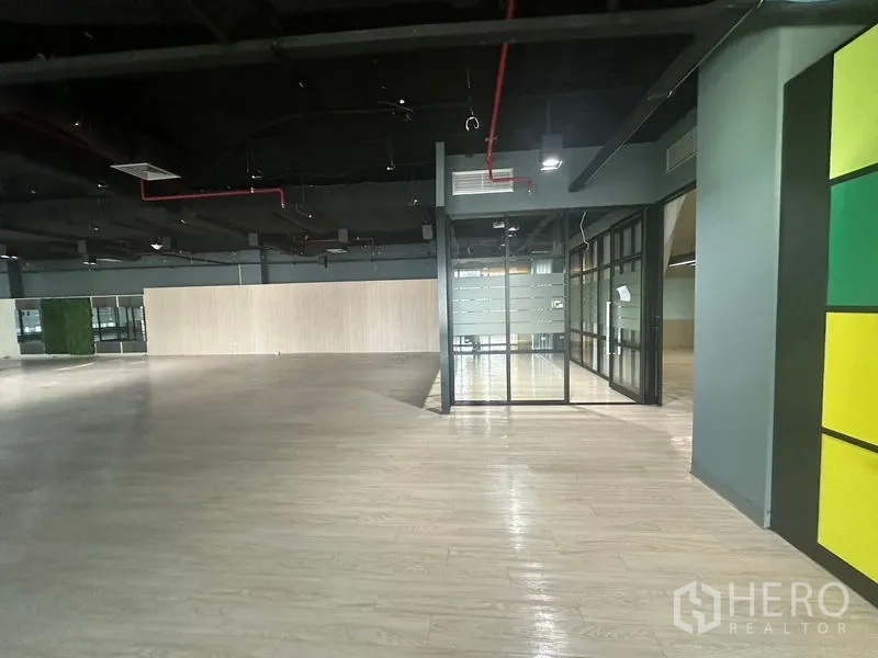 Office Space for rent in Bang Rak, Bangkok - Open workspace facing banks of frosted-glass rooms and exposed ceiling services.