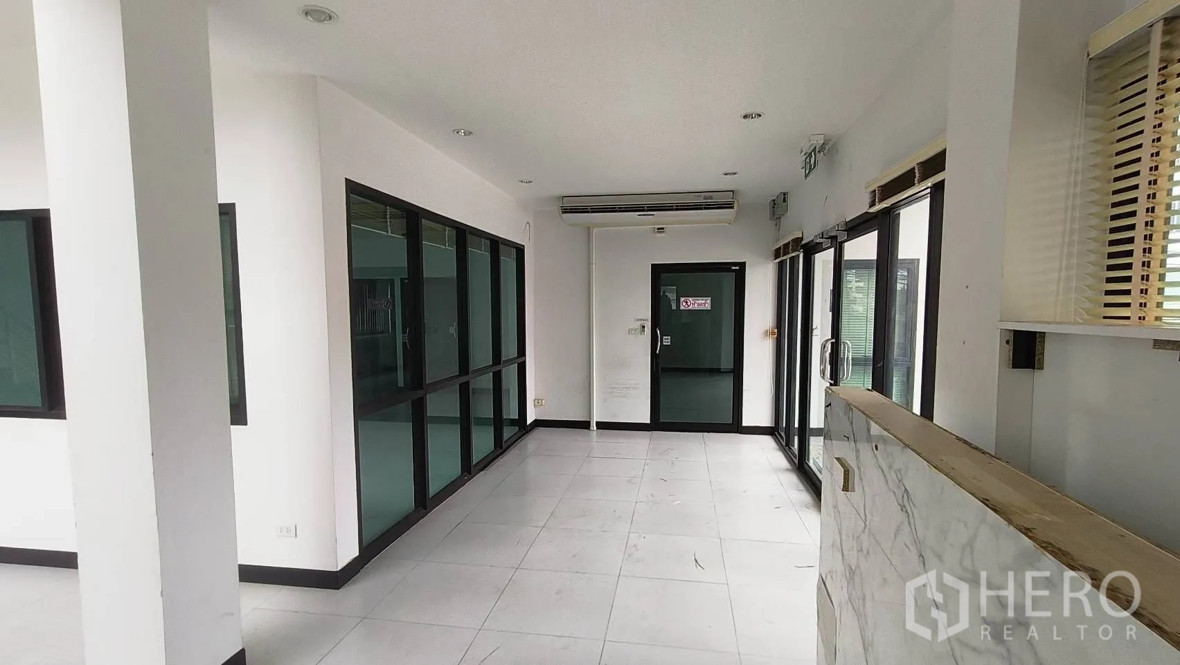 Office Space for rent in Khlong Toei, Bangkok - Glass-walled reception corridor with sliding doors and ceiling air conditioner.