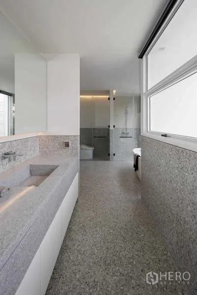 Home Office for rent in Bang Phli, Samut Prakan - Long bathroom with terrazzo vanity, large mirror and glass-enclosed shower zone.