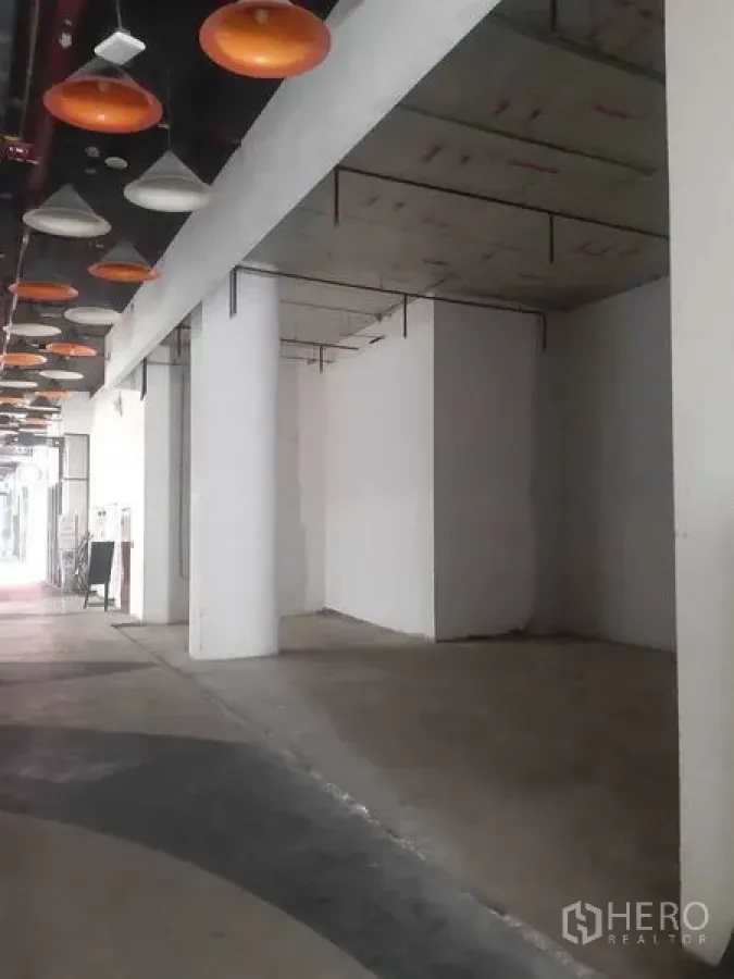 零售空间 出租在Bang Khen, Bangkok - 室内步行廊，沿线多间商铺与橙色吊灯